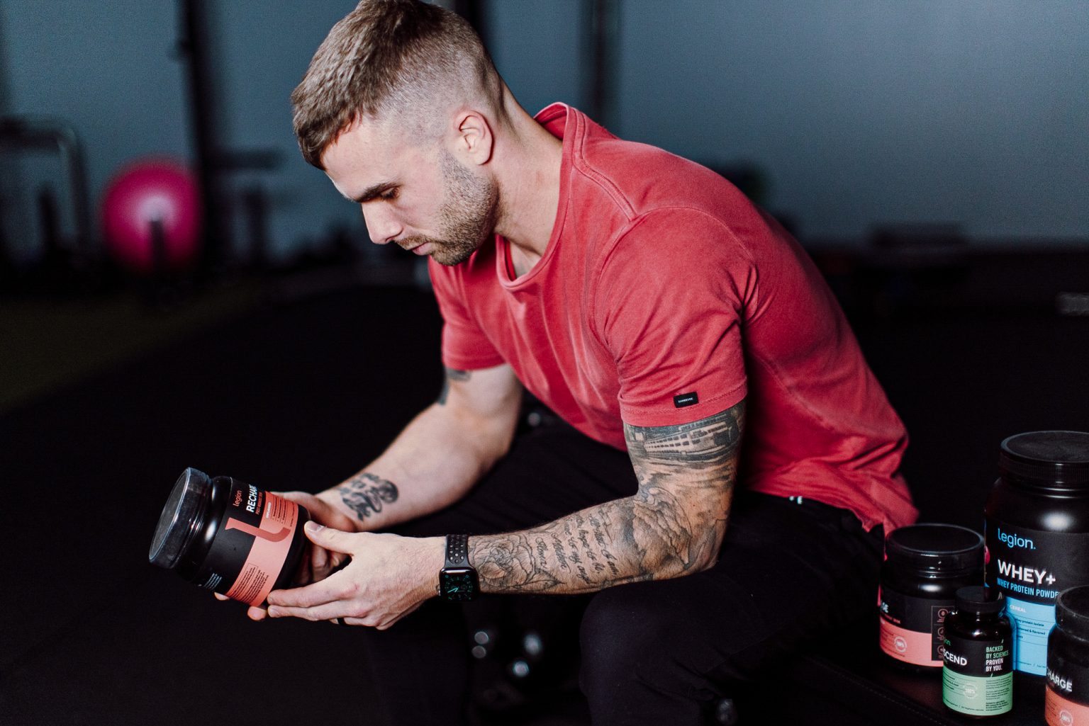 Coach Cody looking at a bottle of Legion's Recharge supplement