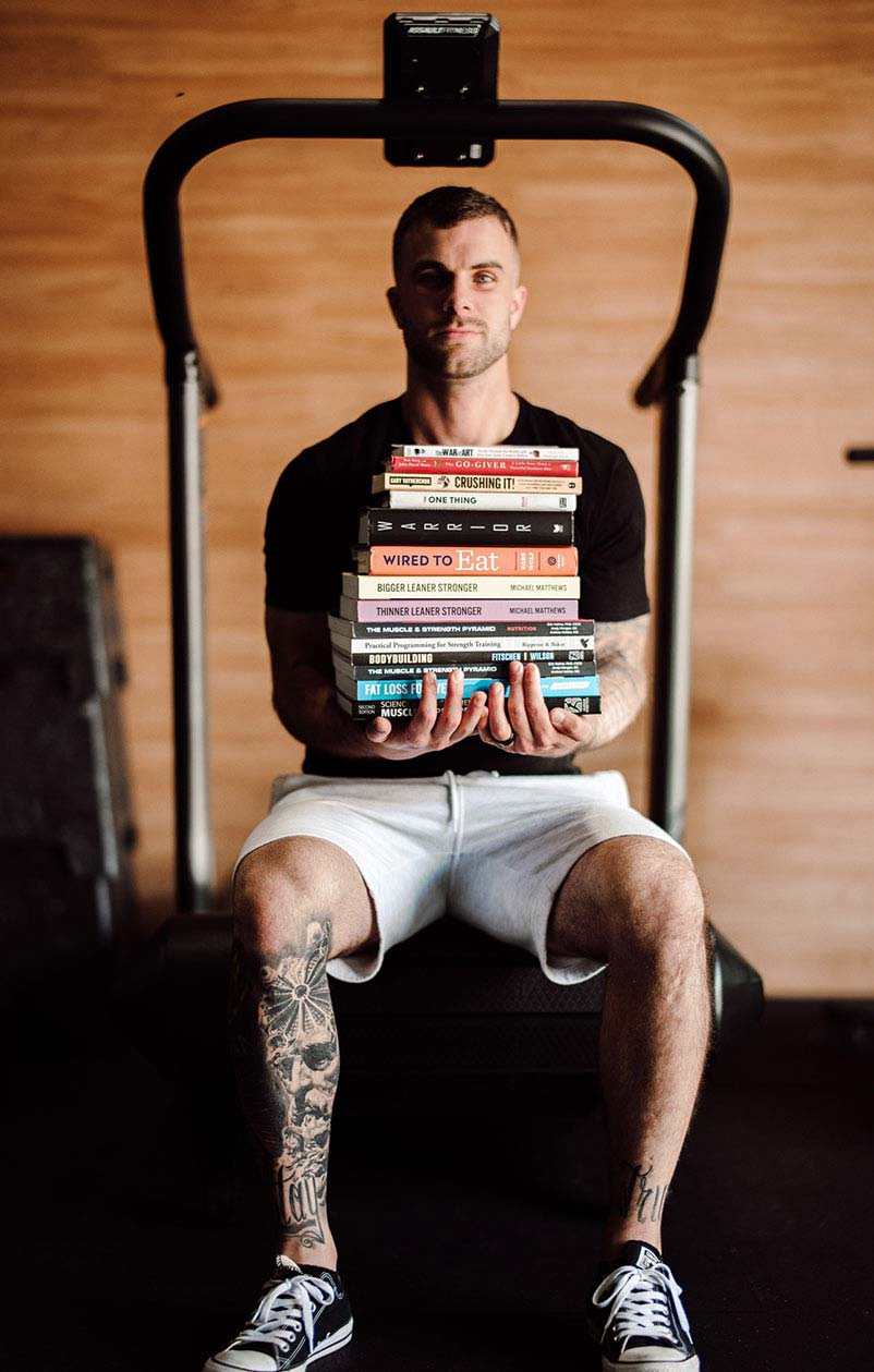 Cody McBroom holding a pile of books