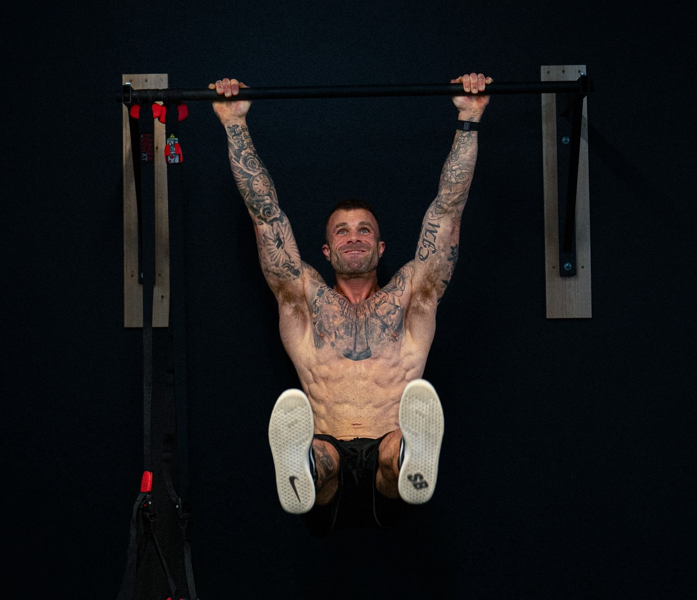 Online Fat Loss Coach, Cody McBroom, of Tailored Coaching Method, performing hanging leg raises.