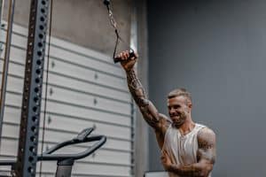 Cody McBroom, owner and founder of Tailored Coaching Method performing single-arm cable lateral raise