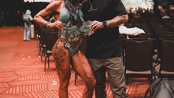 Coach Cody McBroom, founder of Tailored Coaching Method, with his client Kimi Girmus at Emerald Cup 2026, where she won 6 medals across Bikini and Wellness Physique Competition Categories.