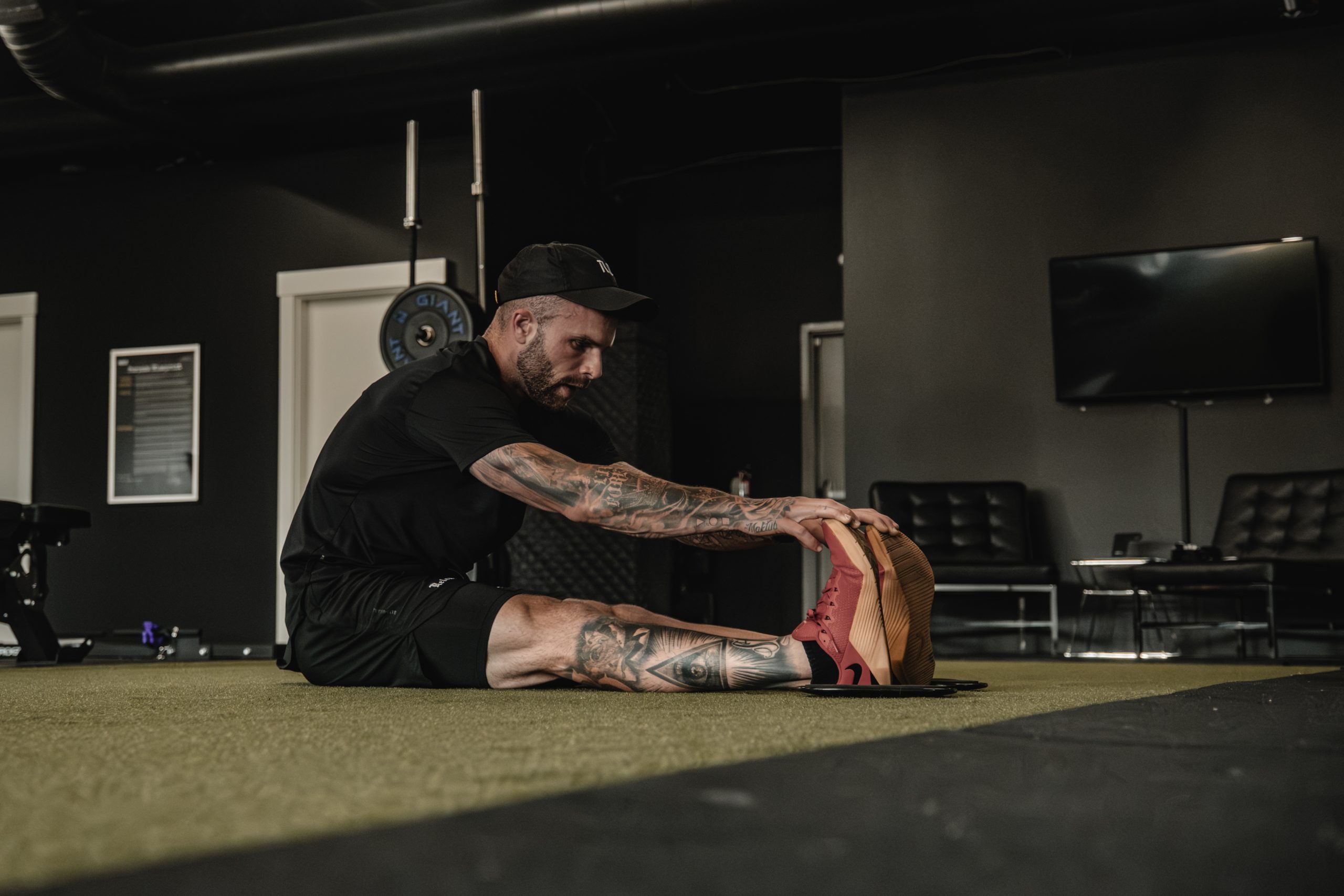 Athlete stretching, foam rolling and practicing box breathing after a training session.